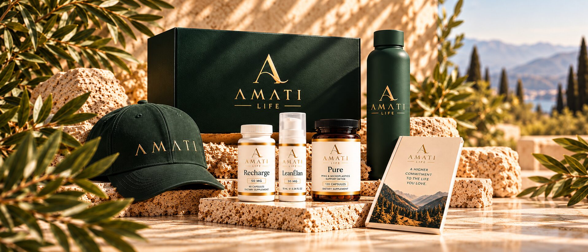 The AMATI LIFE collection on Mediterranean stone: a green presentation box, cap, Recharge, LeanÉlan and Pure, a water bottle and a journal